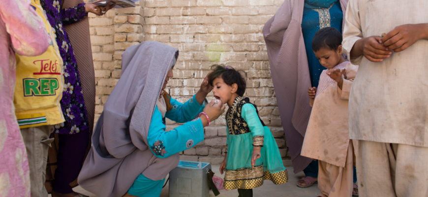 Photo of Afghanistan female polio diplomate administering a polio vaccine to a child