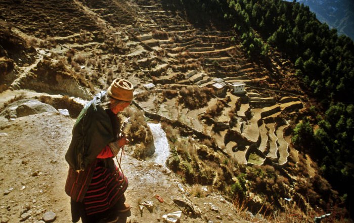Photo: Mountain populations of Asia are particularly prone to vulnerability. A woman in traditional dress performs a prayer ritual in the Himalayas, Namche Bazar, Nepal.